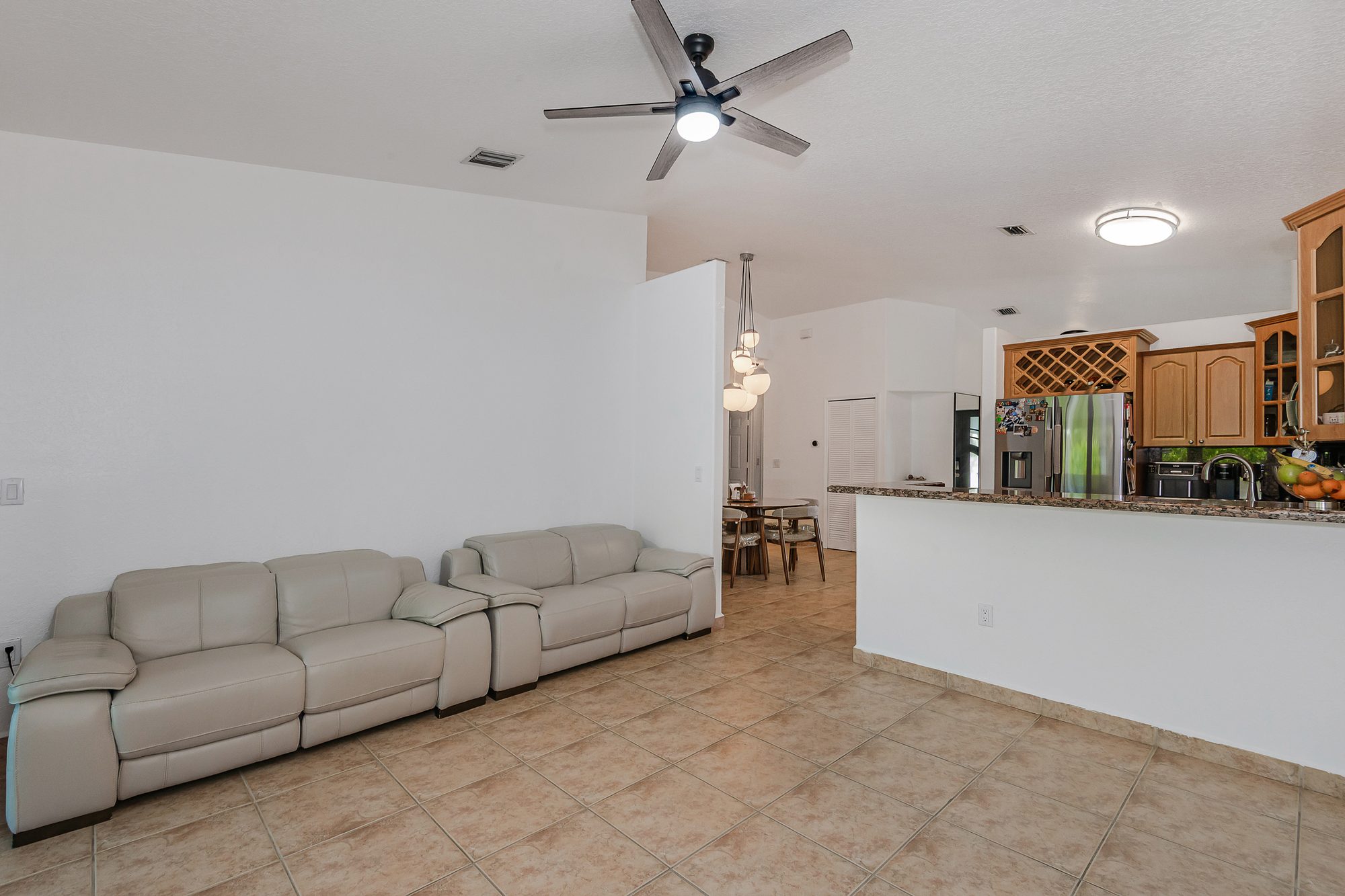 Open living room and kitchen with tile flooring